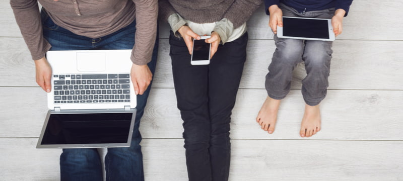 Top view of young family using smartphone, tablet and laptop