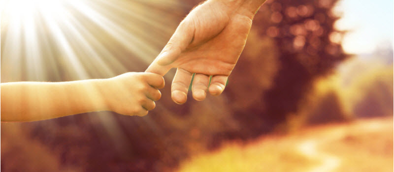 The parent holds the hand of a small child