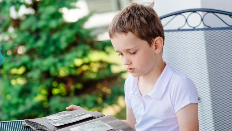 Little boy browsing old photo album